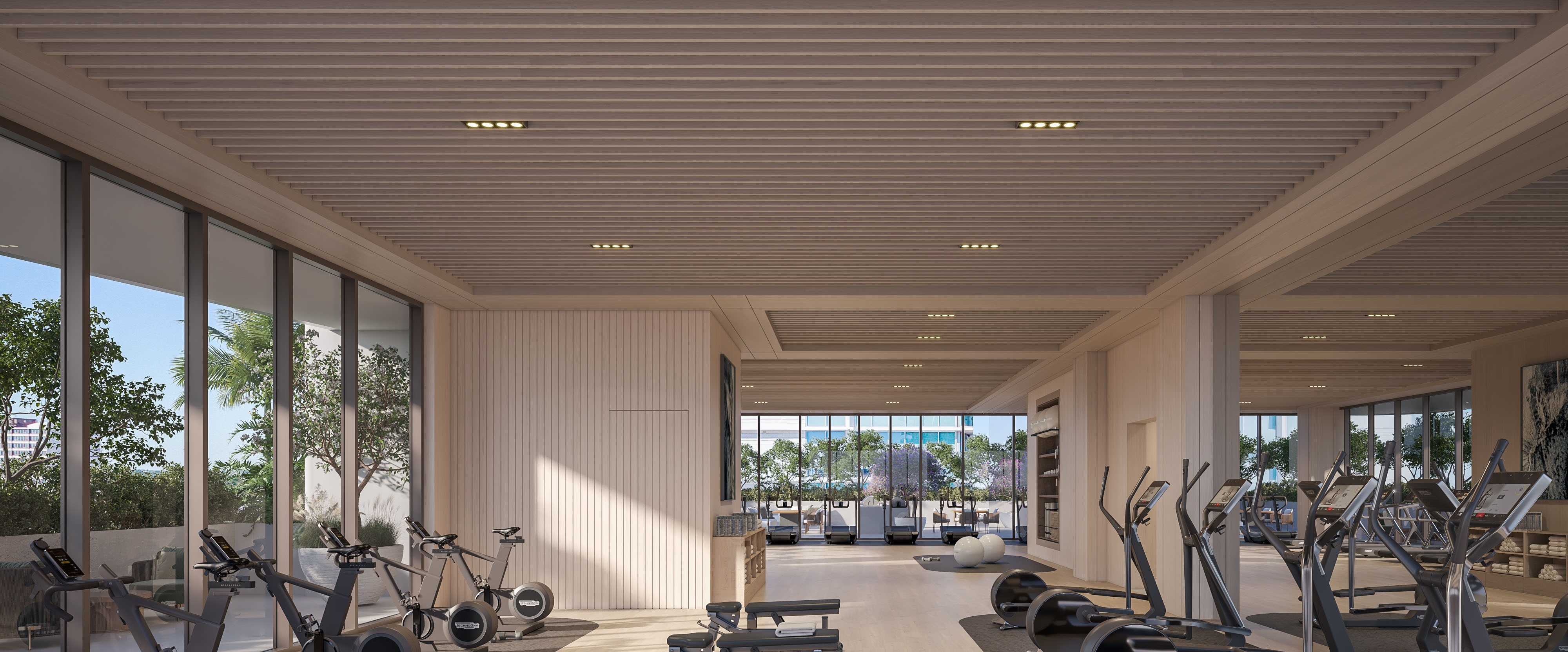 State-of-the-art fitness center at Sage Intracoastal Residences — latest equipment, water views, with adjacent yoga lawn and movement studio.